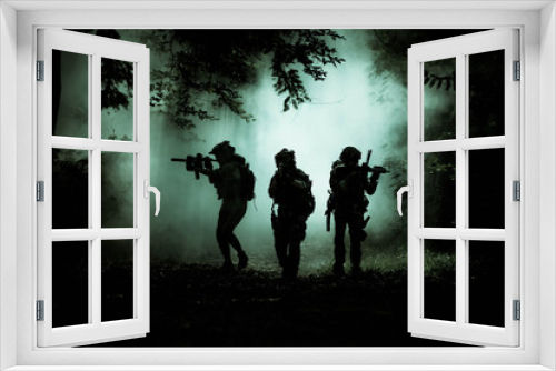 Fototapeta Naklejka Na Ścianę Okno 3D - The action soldiers walking hold weapons with smoke light at night time background.
