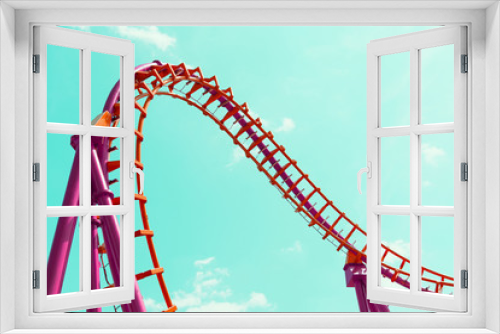 Fototapeta Naklejka Na Ścianę Okno 3D - A roller coaster design in orange and pink against a blue sky.