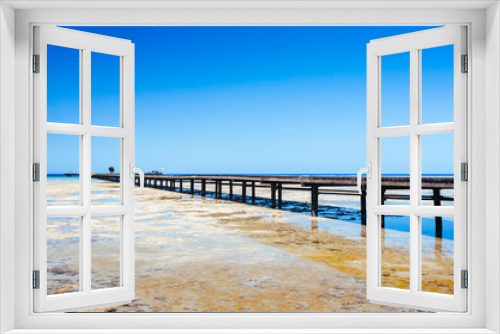 Fototapeta Naklejka Na Ścianę Okno 3D - Beautiful view of the tropical coast with a long pantone. A large wooden pier is on the sandy beach of the resort. Landscape of the sea coast