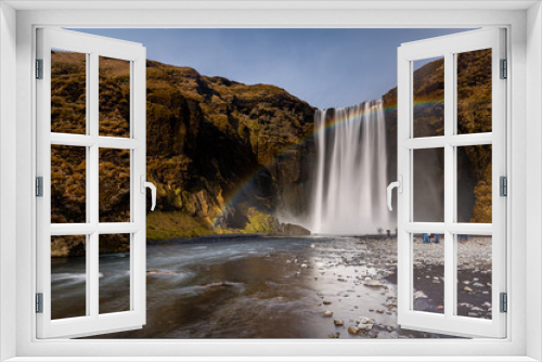 Fototapeta Naklejka Na Ścianę Okno 3D - Skogafoss waterfall in South Iceland with a beautiful rainbow. Tourists admiring the waterfall. Popular and famous tourist attraction.