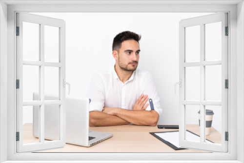 Young business man with a mobile phone in a workplace looking side