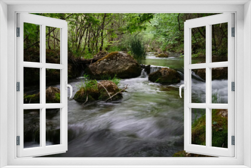 Fototapeta Naklejka Na Ścianę Okno 3D - Full-flowing river in a green sunny forest.