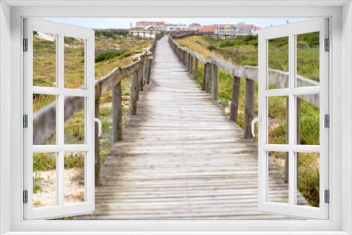 Fototapeta Naklejka Na Ścianę Okno 3D - Wooden path at over sand dunes. Wooden footbridge of Costa Nova beach in Aveiro, Portugal.