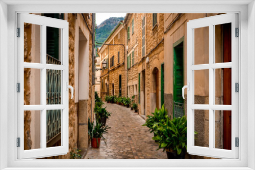 Fototapeta Naklejka Na Ścianę Okno 3D - quaint narrow alley in mediterranean flair lined with pot plants inside the old town of soller, popular travel destination in mallorca