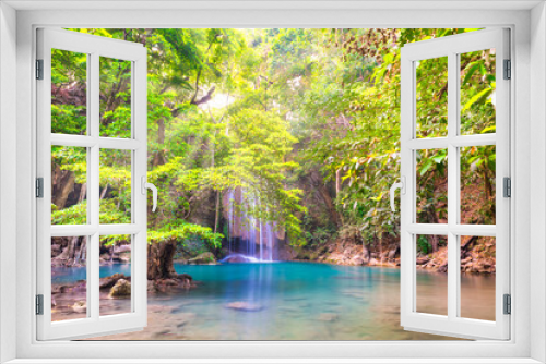 Fototapeta Naklejka Na Ścianę Okno 3D - Beautiful waterfall in tropical jungle forest with big green tree and emerald lake on foreground. Nature landscape of Erawan National park, Kanchanaburi, Thailand