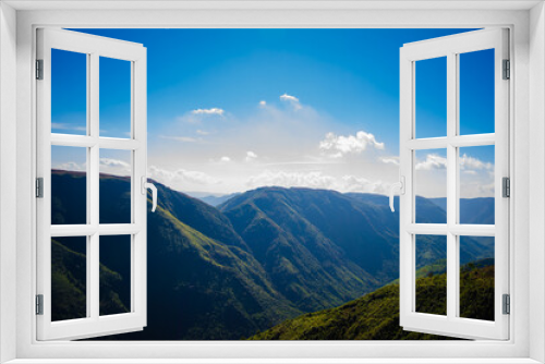 Fototapeta Naklejka Na Ścianę Okno 3D - Natural view of the folded mountains and lush green valleys with clear sky and clouds of Cherrapunji, Meghalaya, North East India
