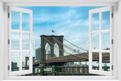 Fototapeta Naklejka Na Ścianę Okno 3D - Iconico puente de Brooklyn en Nueva York, Usa. Arquitectura a gran escala de piedra con bandera ddel pais sobre cielo parcialmente nubado azul. 