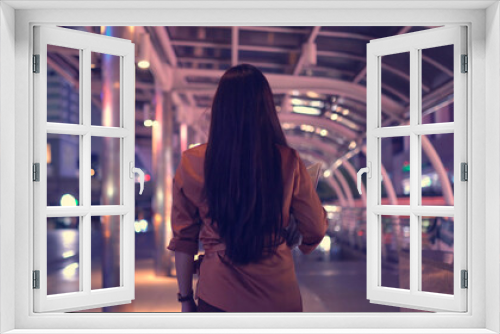 Young asian woman walking in the night city streets