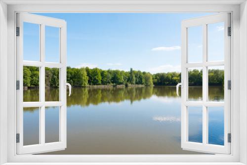 Fototapeta Naklejka Na Ścianę Okno 3D - Beautiful lake during the spring season, Flers, Normandy, France. Green foliage in the background that reflects in the water. Sunny day in the park.