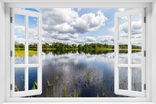 Fototapeta Naklejka Na Ścianę Okno 3D - Wonderful landscape with lake on a sunny summer day. Blue sky with cumulus clouds reflected in calm water. Latvia. 