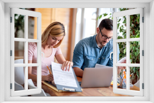 Couple using their laptop to pay  bills from home