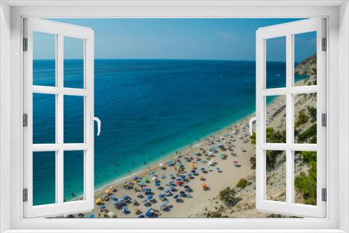 Fototapeta Naklejka Na Ścianę Okno 3D - Photo of Egremni beach with turquoise water and full of people sunbathing at Lefkada island, Greece