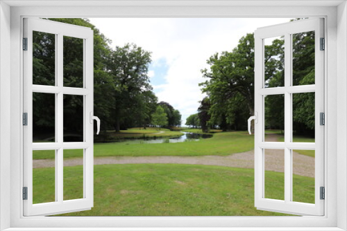 Fototapeta Naklejka Na Ścianę Okno 3D - 
Beautiful view over a summer park with a pond landscape surrounded by old trees such as chestnut and beech. Photo was taken on a sunny day.