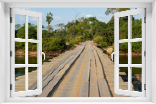 Fototapeta Naklejka Na Ścianę Okno 3D - Wooden rustic bridge over river in dangerous dirt road in the amazon rainforest, Brazil. Driver POV. Concept of transport, logistics, travel, ecology, danger, off road and co2.
