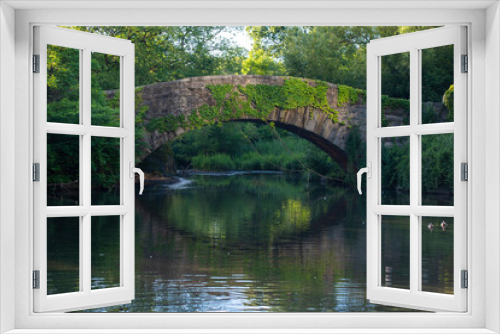 Fototapeta Naklejka Na Ścianę Okno 3D - Serene Landscape of an Arched Bridge Over a Pond