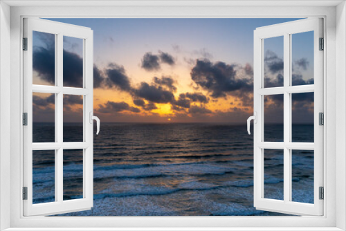Fototapeta Naklejka Na Ścianę Okno 3D - Beautiful sunset with dark blue sky and orange golden colors sun over the sea with dramatic clouds in the sky and waves close to the beach shore concept of romantic time on vacation