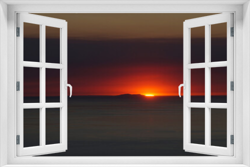 Fototapeta Naklejka Na Ścianę Okno 3D - A Vessel Passes Near Front of St. Nicolas Island During The Final Moments of an Epic Sunset