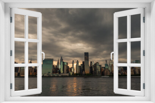 Fototapeta Naklejka Na Ścianę Okno 3D - Dark and Ominous Sky with the Midtown Manhattan Skyline during a Sunset along the East River in New York City