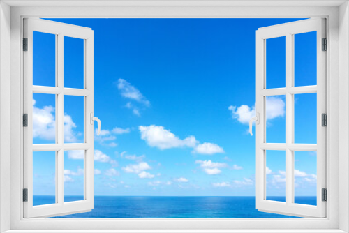 Aerial view of clear Ocean water with blue cloudy sky.
