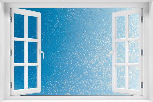 Fototapeta Naklejka Na Ścianę Okno 3D - Blurred water drops on sky background, bokeh on blue background.
