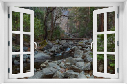 Fototapeta Naklejka Na Ścianę Okno 3D - View of the winter Bridalveil Fall, trees, huge river rocks and Tuolumne River in Yosemite Park, California.