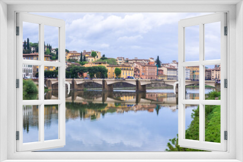 Florence or Firenze, Ponte delle Grazie bridge, landmark on Arno river, landscape with reflections on the water. Tuscany, Italy. 