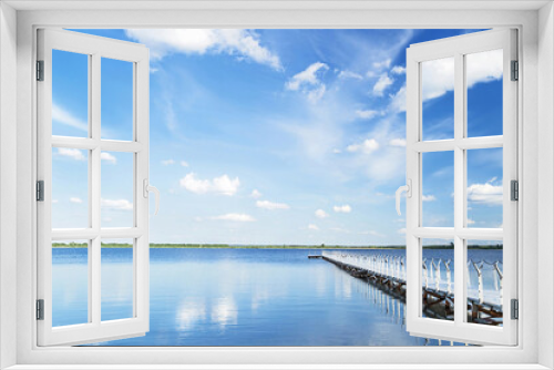 Fototapeta Naklejka Na Ścianę Okno 3D - Blue sky with light clouds, blue water and white pier in the sunny summer day.