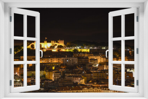Night view of old town and Sao Jorge Castle from Sao Pedro de Alcantara viewpoint (miradouro), in Lisbon, Portugal