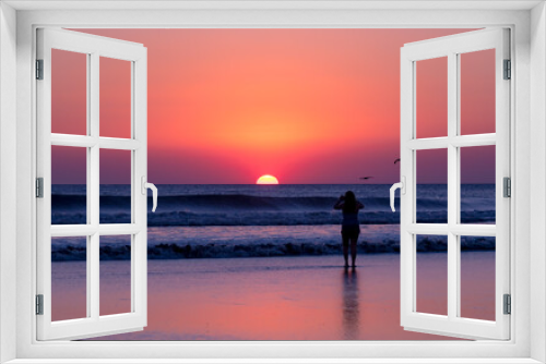 Fototapeta Naklejka Na Ścianę Okno 3D - Girl takes a photo of the sunset on the beach, birds, shadows, sunset. 