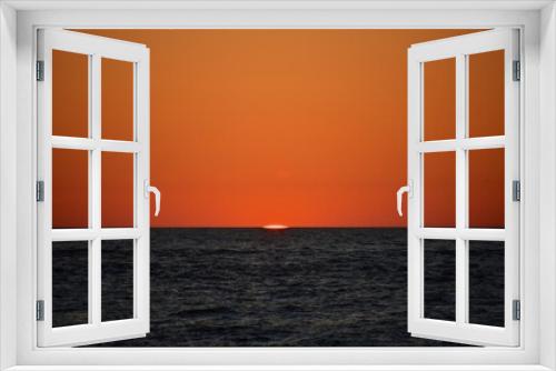 Fototapeta Naklejka Na Ścianę Okno 3D - A cold orange sun sets on the North Sea. Fall. Cold evening. Photo from the side of the ship.