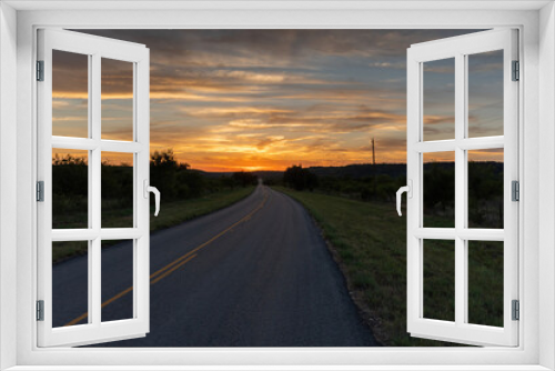 Fototapeta Naklejka Na Ścianę Okno 3D - Rural country road leading to a beautiful orange sky at sunset