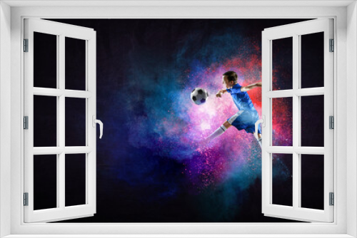 Fototapeta Naklejka Na Ścianę Okno 3D - Boy playing soccer hitting the ball
