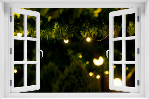 Fototapeta Naklejka Na Ścianę Okno 3D - illumination backyard light garden with electric garland bulb of warm light bulbs, dark illuminate night scene of outdoor park nobody.