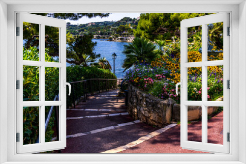 Fototapeta Naklejka Na Ścianę Okno 3D - Stairs leading to the sea coast. Beautiful summer atmosphere, flower beds. Scenic view. Sunny day. Vacation, holiday. Beautiful beach background. High quality photo
