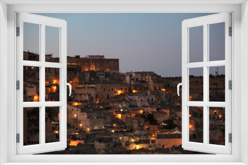Fototapeta Naklejka Na Ścianę Okno 3D - Amazing lighted buildings in ancient Sassi district by night in Matera, well-known for their ancient cave dwellings. Basilicata. Italy
