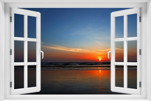 Fototapeta Naklejka Na Ścianę Okno 3D - Stunning sunset at the beach as the sun is just about to dip over the horizon.  Horizontal format this conveys of concepts of vacation, getaways, peace, tranquility, rest, quiet.