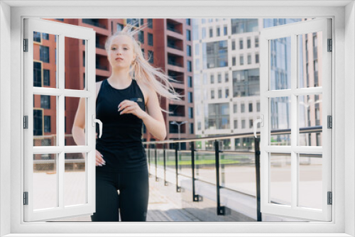 A stylish young girl in sportswear runs among the skyscrapers in the fresh air for weight loss.