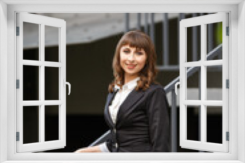 Young woman weared in classic business suit on background of a City park. Business style girl in Summer City on background of new park near a building. Street style Modern strict urban girl.