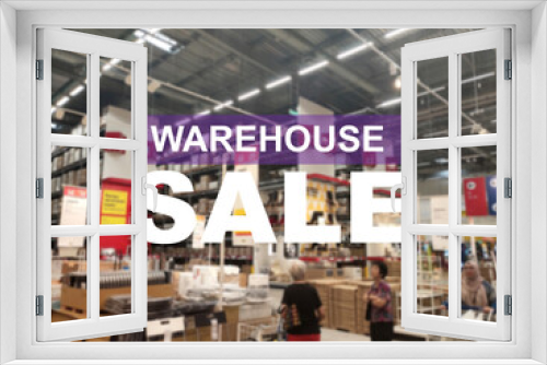 The word WAREHOUSE SALE is clearly written against the background of an image of a department store in a large warehouse. The image has been blurred.