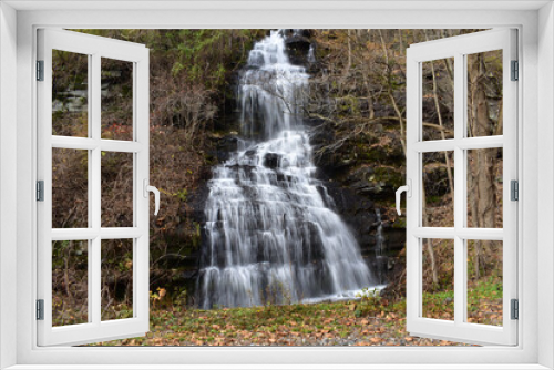 Fototapeta Naklejka Na Ścianę Okno 3D - A Small Waterfall Flowing Down a Steep Cliff