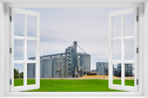 Fototapeta Naklejka Na Ścianę Okno 3D - Granary elevator. Agro manufacturing plant for processing drying cleaning and storage of agricultural products, flour, cereals and grain. Agribusiness concept