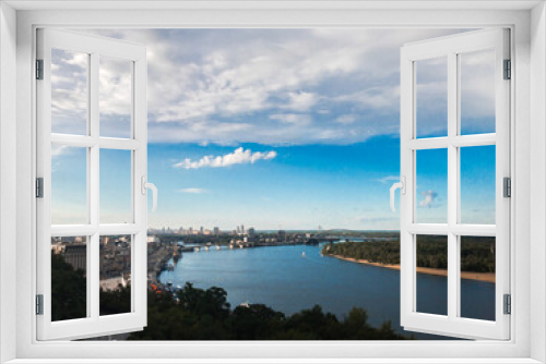 Panoramic view of Dnipro river and side of Kyiv from the point view. Blue sky, green grass and urban landscape of Kyiv, Ukraine.