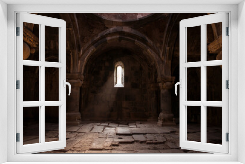 Fototapeta Naklejka Na Ścianę Okno 3D - Interior of old Sanahin Armenian Monastery of the Armenian Apostolic Church with ray of light entering through narrow window and headstones on uneven ground
