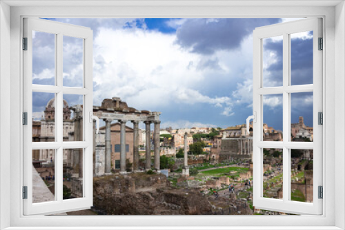 Roman forum under the sun against a stormy sky. Italy.