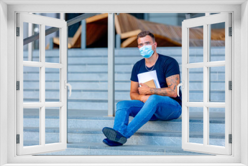 young man do his homework on the steps of the University campus