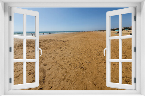 Fototapeta Naklejka Na Ścianę Okno 3D - La Barrosa beach in Sancti Petri, Cádiz, with a large amount of sand without water as the tide is low