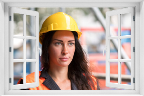 Cute factory female employee wearing a yellow protective helmet