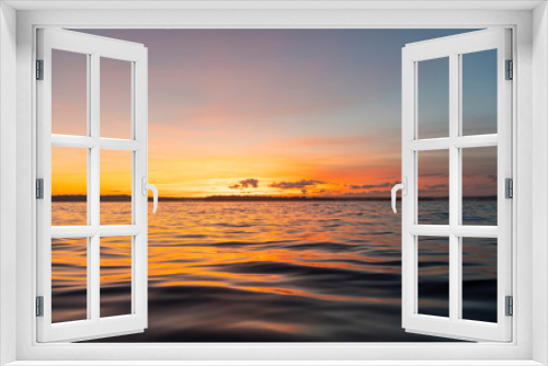 Fototapeta Naklejka Na Ścianę Okno 3D - Water surface. View of a Sunset sky background. Dramatic gold sunset sky with evening sky clouds over the sea. View of a Crystal clear sea water texture. Landscape. Small waves. Water reflection