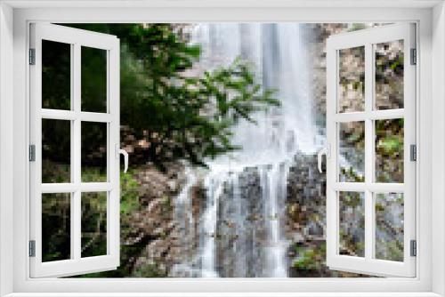 Fototapeta Naklejka Na Ścianę Okno 3D - •	Waterfall in Zhangjiajie Grand Canyon, Hunan province. The water flows down from the mountain peak to the canyon. The silk-like smooth water, the cliff, the trees, the blue sky and the reflection ar