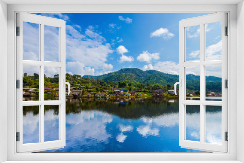 Fototapeta Naklejka Na Ścianę Okno 3D - The village next to the river. The backdrop has mountains and beautiful blue turquoise sky. The river has a beautiful reflection. Village in Pai, Mae Hong Son, Thailand